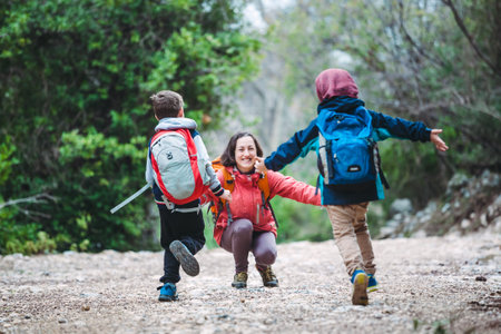 Niño pequeño con mochila de senderismo en camino de montaña con sus padres