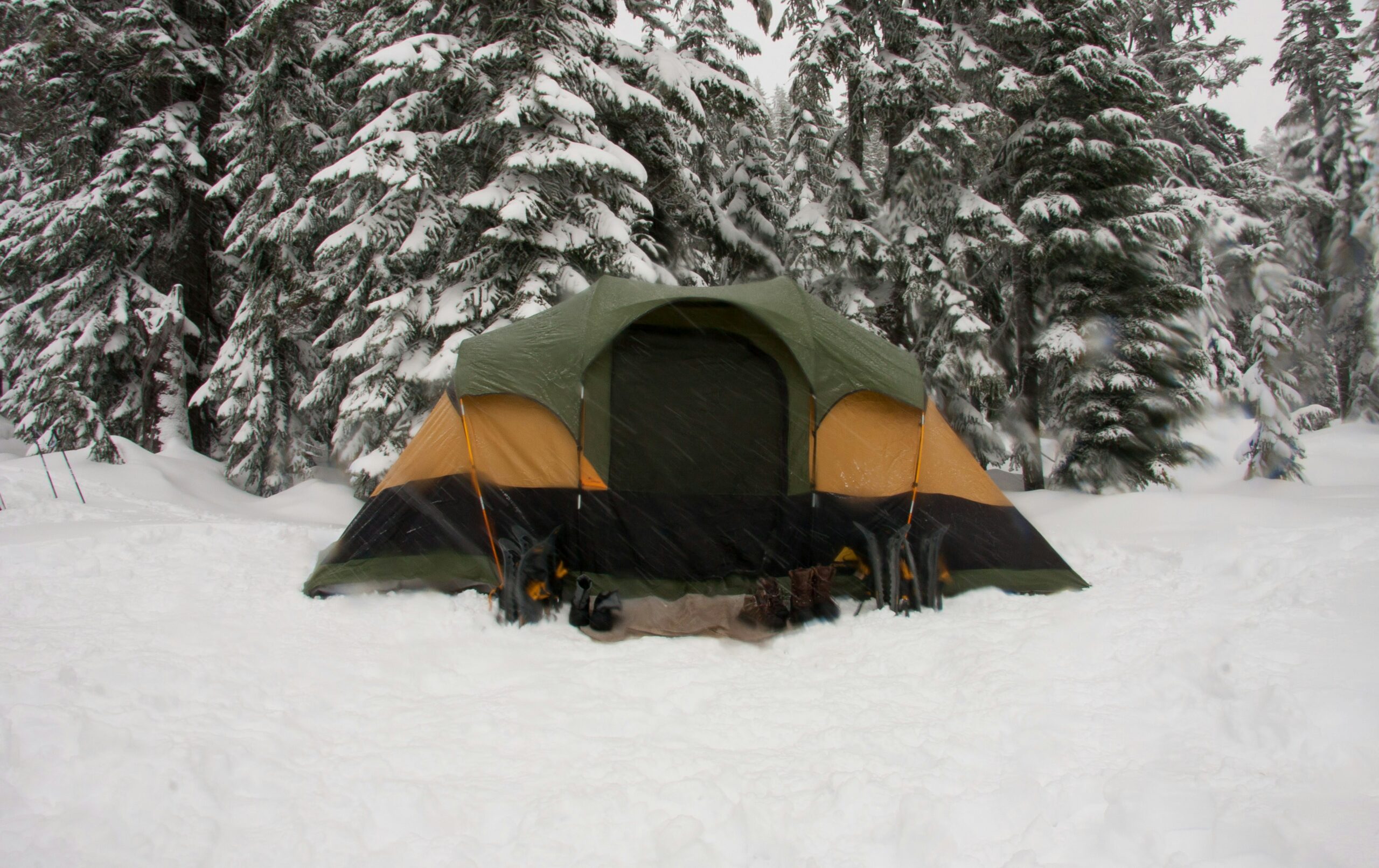 Familia dentro de una tienda de campaña de invierno protegida de la nieve en la montaña.