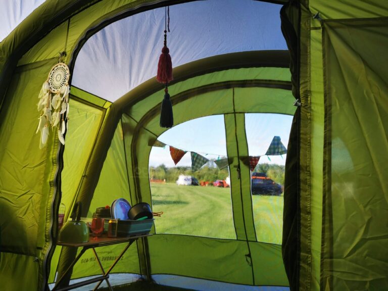 Tienda de campaña hinchable Vango Odyssey Air 600 montada en un camping familiar verde.